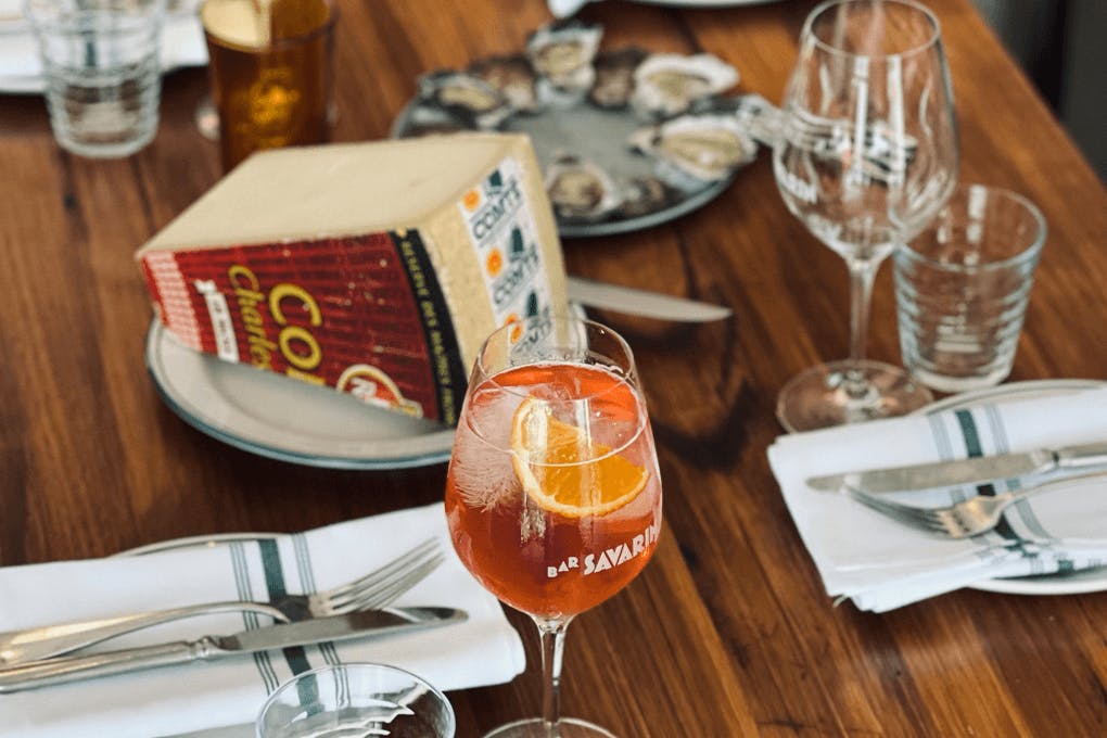 A table set with cutlery glasses and cheese.